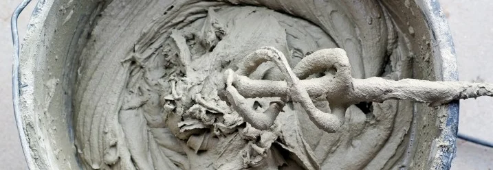 Eimer mit Fliesenkleber und Rührer.